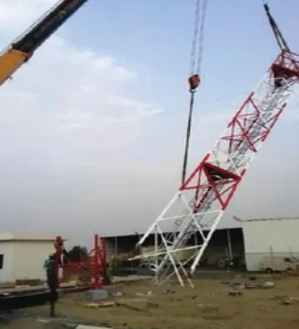 Crane lifting a lattice tower section during erection